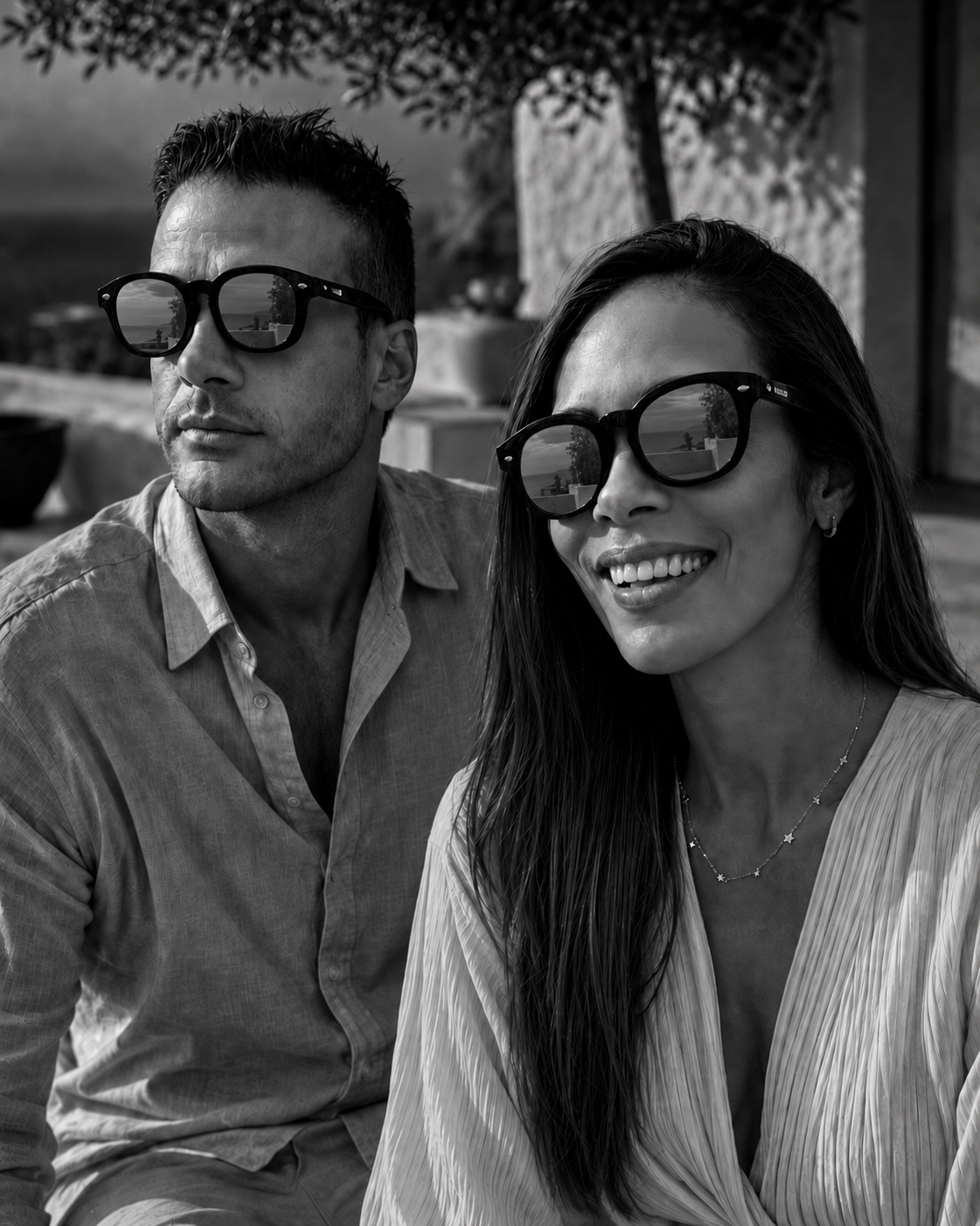 A couple wearing HALO frames with the magnetic sun overlays fitted, photographed in black and white at golden hour